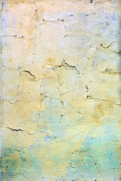 Eine Wand mit rissiger gelber und blauer Farbe. schöner Hintergrund. Textur der alten Hülle mit Rissen. — Stockfoto