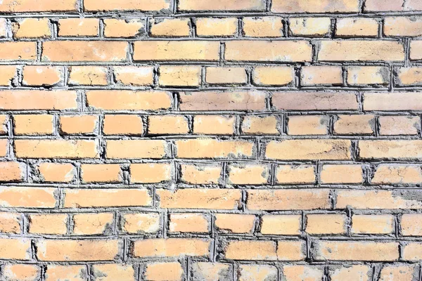 En vägg av slät gul tegel. Tom textur bakgrund av murverk. — Stockfoto