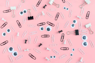 İleti örneği ve kukla gözler düzensizce pembe bir arka plan üzerinde dağınık vardır. Ortasında bir surat, bir yüz kağıt klip yaptı. Neşeli arka plan.