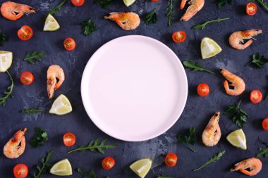Dokulu bir arka plan üzerinde boş bir pembe levha, gıda dağılmış. Karides, limon ve Yeşiller. Yukarı alay, metin için boşluk. Düşük anahtar içinde renkli fotoğraf.