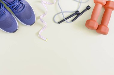 Fitness arka plan metin için yer ile. Mavi spor ayakkabıları, halter, ip ve şerit metre atlayarak. Yukarı alay.