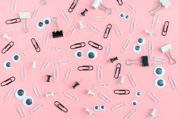 İleti örneği ve kukla gözler düzensizce pembe bir arka plan üzerinde dağınık vardır. Ortasında bir surat, bir yüz kağıt klip yaptı. Neşeli arka plan.