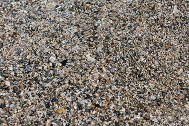 Arka plan kahverengi çakıl taşları ile. Yuvarlak deniz çok renkli taşlar. Küçük çakıl taşları.