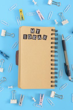 Ortasında bir açık defter yayları olan kahverengi sayfaları üzerinde yatıyor. İleti örneğinde bozukluk mavi bir arka plan üzerinde. Yazıt benim fikir. Güzel bahçe. Yukarı alay.