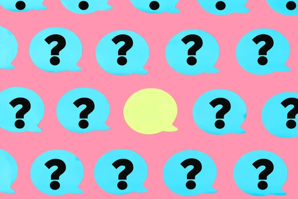 Photo, blue stickers with question marks on a pink background. In the center is an empty yellow sticker. A beautiful bright pattern, a place for an inscription.