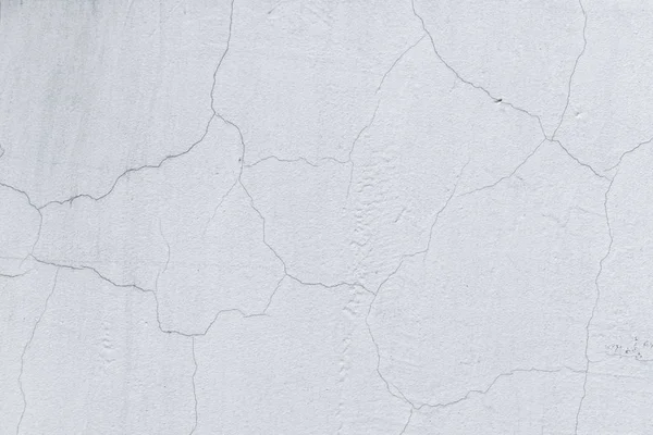 Çatlaklar ile beton beyaz duvar. Bir olağandışı dokulu arka plan.
