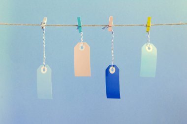 İple buruşuk renkli clothespins, onlar puffs içinde sıkı tutun. Bir yazıt, yukarı alay etmek için bir yer. Soluk mavi arka plan üzerinde olağandışı bir fotoğraf.