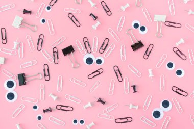 Kukla gözleri ve kaşları pembe bir arka plan klipleri gelen garip bir yüz. İleti örneğini düzensizce dağınık olduğunu. Alışılmadık bir arka plan klipleri ve büro düğmeleri. Üstten güzel fotoğraf.