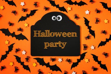 Dekoratif yarasalar, yıldız ve örümcekler bir turuncu zemin üzerine yerleştirilir. Parlak yazıt merkezinde, Cadılar Bayramı partisi. Tatil için korkunç resim.