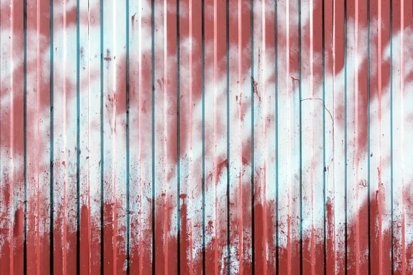 从波纹金属栅栏 表面涂上红色和浅蓝色 油漆斑点 空背景 — 图库照片