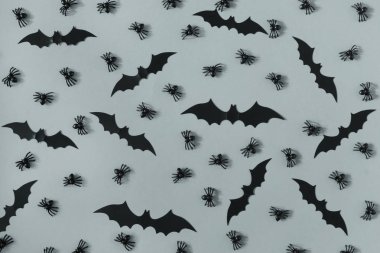 Dekoratif siyah örümcekler ve yarasalar çok gri yüzeyde ortaya konulan. Güzel Cadılar Bayramı arka plan.