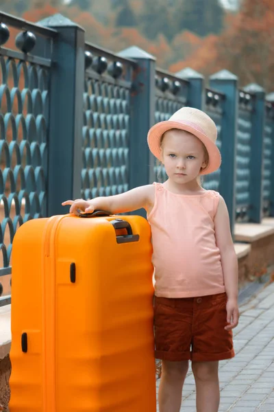 Een Klein Meisje Staat Naast Een Grote Oranje Koffer Een — Stockfoto