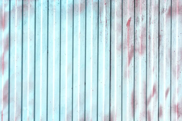 Fence from corrugated metal. Finish painted pale turquoise color, spots and stains burgundy paint. Empty background.