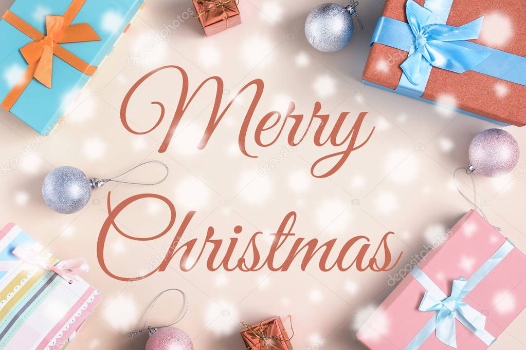 merry christmas lettering on surface with gifts and decorations
