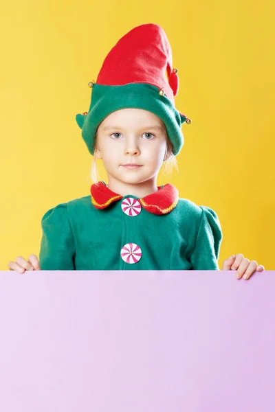 小女孩在圣诞节精灵服装站在后面的地方文本黄色背景 — 图库照片