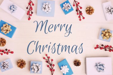 yazıt Merry Christmas ve küçük hediye kutuları ok, koni ve dekoratif kırmızı meyveler 