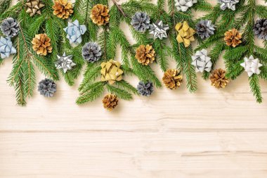 Altın ve gümüş yay ve koniler ile dekore edilmiş Ladin dalları