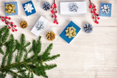 Noel kompozisyon çam kozalakları, hediye kutuları ve kırmızı meyveler