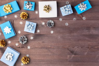 Çam kozalakları ahşap arka plan üzerinde yatan beyaz ve mavi kutuları