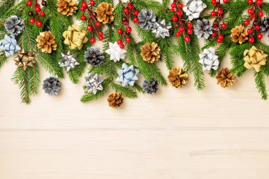 Noel kompozisyon köknar dalı yay, çam kozalakları ve kırmızı meyveler ile dekore edilmiş