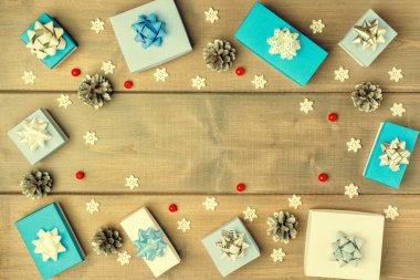 Çam kozalakları ahşap arka plan üzerinde yatan beyaz ve mavi kutuları