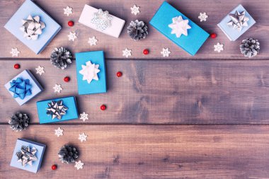 Çam kozalakları ahşap arka plan üzerinde yatan beyaz ve mavi kutuları