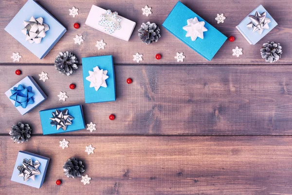 Çam kozalakları ahşap arka plan üzerinde yatan beyaz ve mavi kutuları