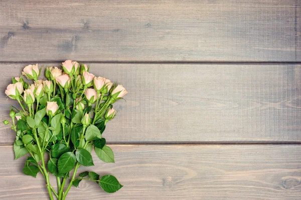 bouquet of small spray roses on wooden planks background