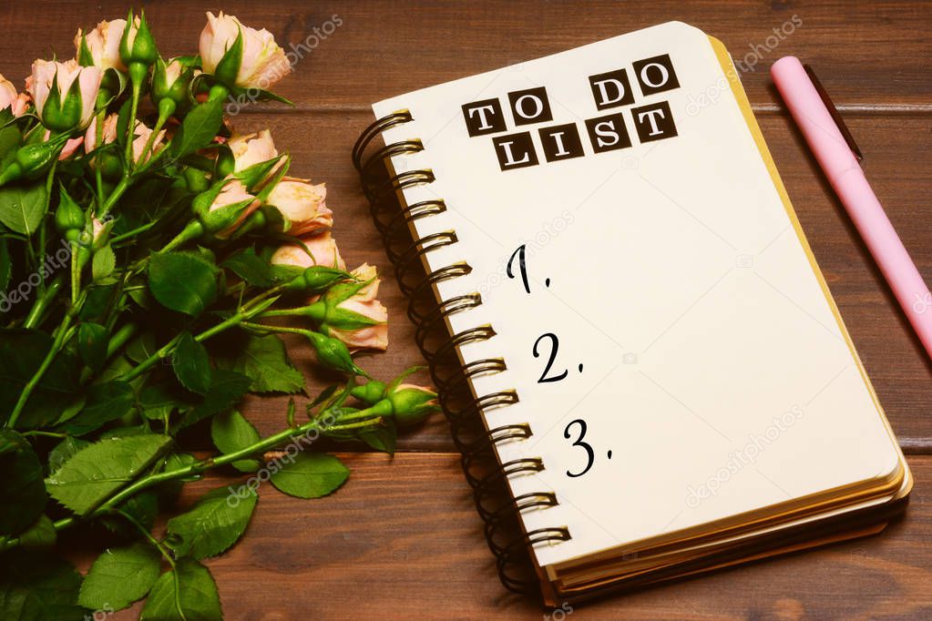 bouquet of roses and inscription To do list on notebook on dark wooden background 