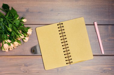 ahşap arka plan üzerinde pembe kalem ve küçük gül buketi 