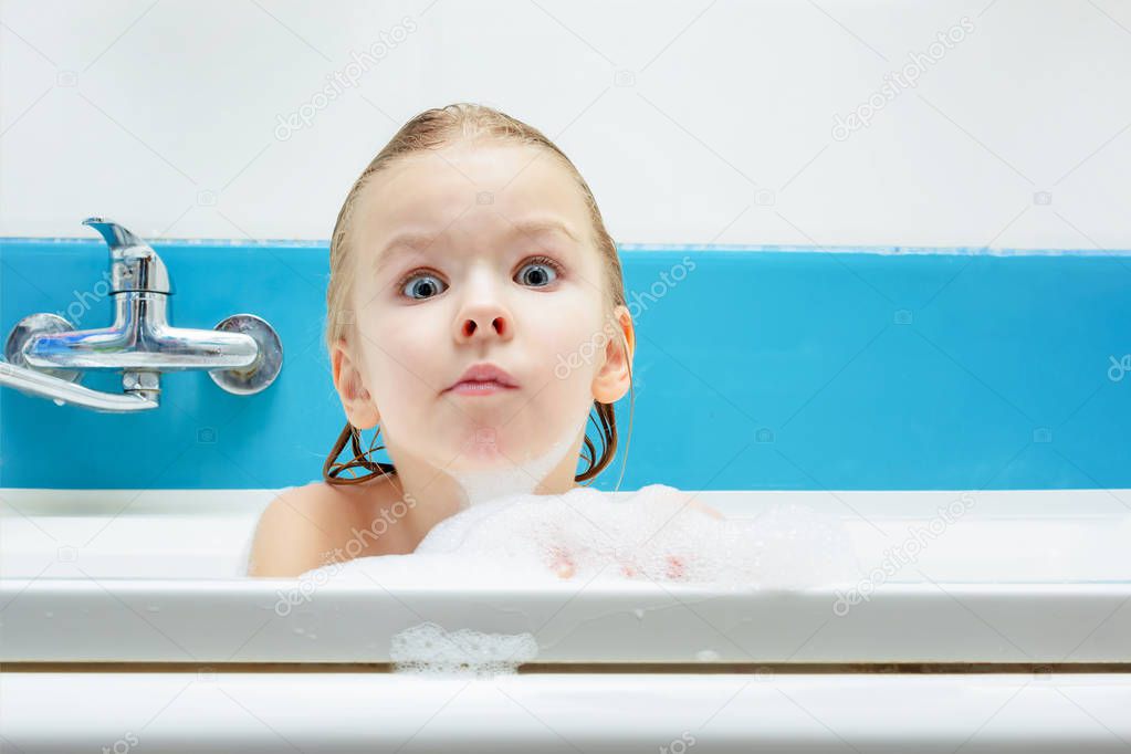Portrait of little girl taking bubble bath at home