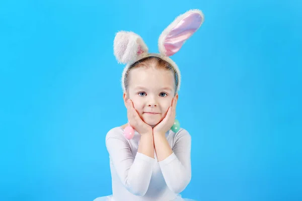 girl wearing white rabbit costume while standing on blue background