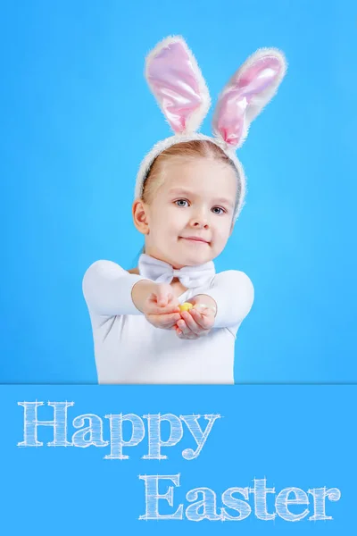 Little girl in rabbit costume holding Easter egg