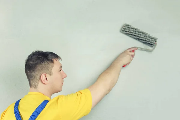 House painter handles wall. Repairman holding roller