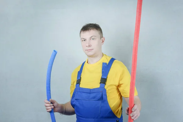 Man Work Clothes Holding Blue Red Pipe — Stock Photo, Image