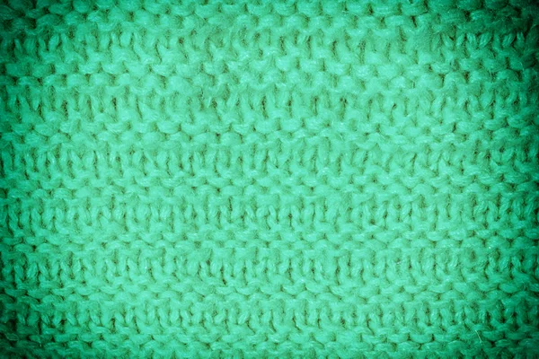 Texture knitted products. Unusual wool pattern close up. Blank green background for layout .