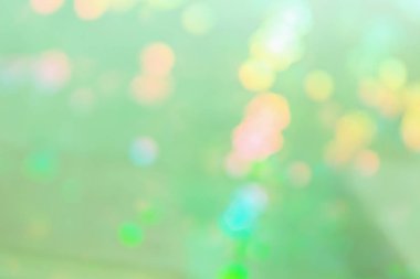 Çok renkli noktalar ile açık yeşil soyut arka plan.