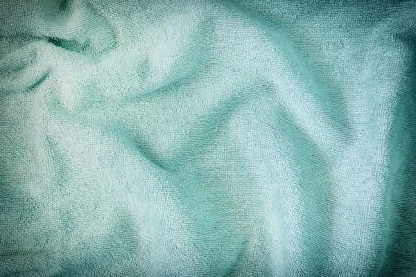 Green crumpled textiles unevenly laid out. The texture of a terry towel. Blank background . — Stock Photo, Image