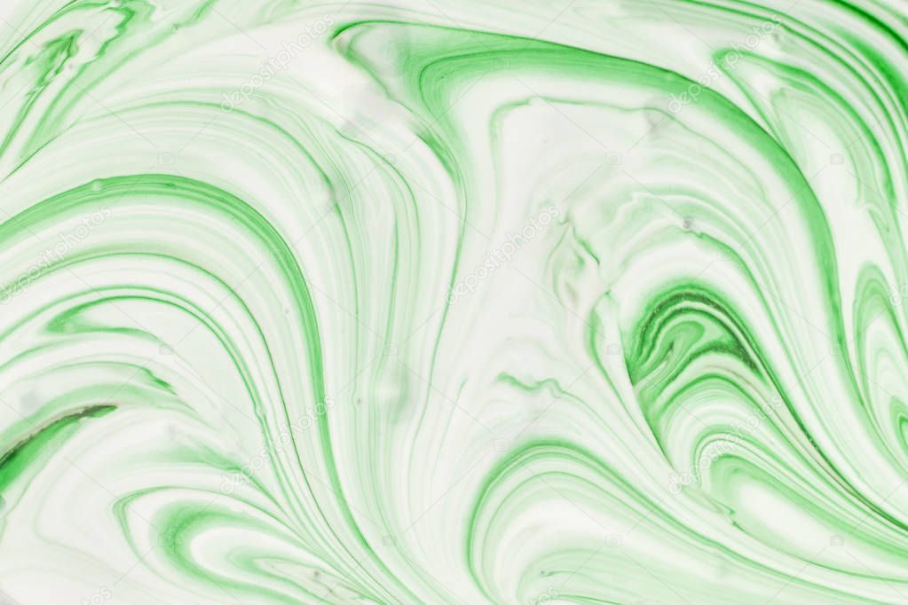 Abstract background for layouts. The process of mixing green and white paint close-up.