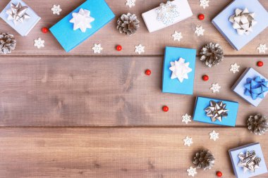 Kopya alanı ile Noel kompozisyon. Hediye beyaz ve mavi kutular, koni, dekoratif kar taneleri ve kırmızı çilek. Şenlikli düzen.