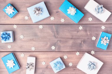 Kopya alanı ile Noel kompozisyon. Yay ve küçük dekoratif kar taneleri ile Hediye kutuları güzel ahşap bir arka plan üzerinde bir daire içinde düzenlenmiştir.