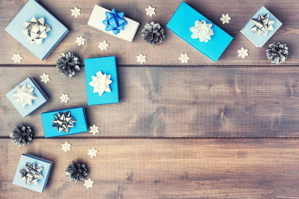 Gift boxes with bows, silver cones and small decorative snowflakes are beautifully arranged in the corner. Christmas composition with copy space. — Stock Photo, Image