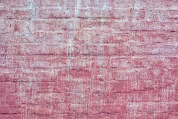 Brick wall painted with red paint. Old paint stains and smudges. Empty background for layouts and sites