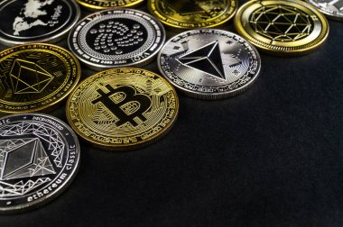 A lot of cryptocurrency coins lie on a dark surface clipart