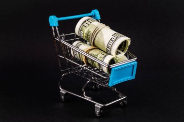 Karanlık arka planda içinde para ile Süpermarket arabası