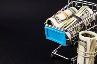 Karanlık arka planda içinde para ile Süpermarket arabası