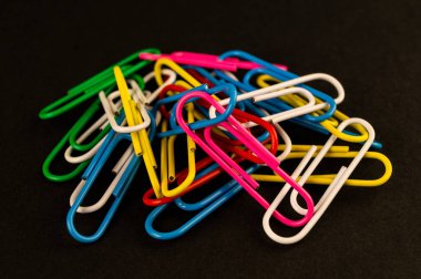 Birçok renkli ataş siyah bir arka plan kağıt üzerinde yalan