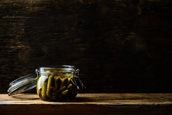 Tarro de vidrio con pepinos caseros en vinagre frescos y bajos en sal en la oscuridad — Foto de Stock