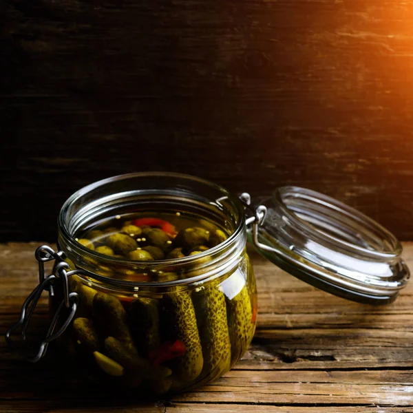 Tarro de vidrio con pepinos caseros en vinagre frescos y bajos en sal en la oscuridad — Foto de Stock