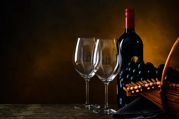 Martwa natura z butelką czerwonego wina, dwa kieliszki i winogron w — Zdjęcie stockowe